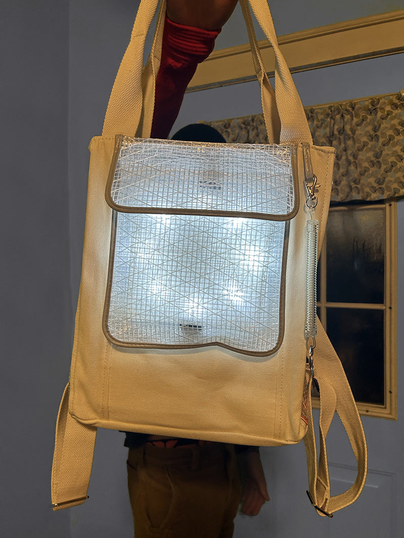 Person holding SolaPack backpack from straps.