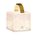 Load image into Gallery viewer, SolarPuff solar lantern glowing in warm light on white background