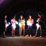 Load image into Gallery viewer, Solar-Lanterns-color- shows a group of teenagers with our multi-color lights in a central park party -they are holding our solar lamps settings on blue, green, and pink- our lamps are perfect for any party -indoor -outdoor-solar-lamp