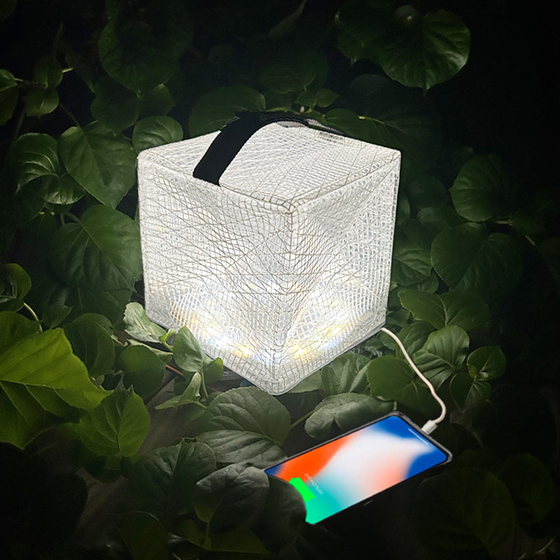 Bright and powerful MegaPuff lantern charging a phone in nature.