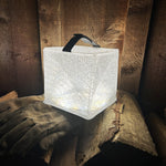 Load image into Gallery viewer, MegaPuff lantern illuminating a wood pile for bright outdoor lighting.
