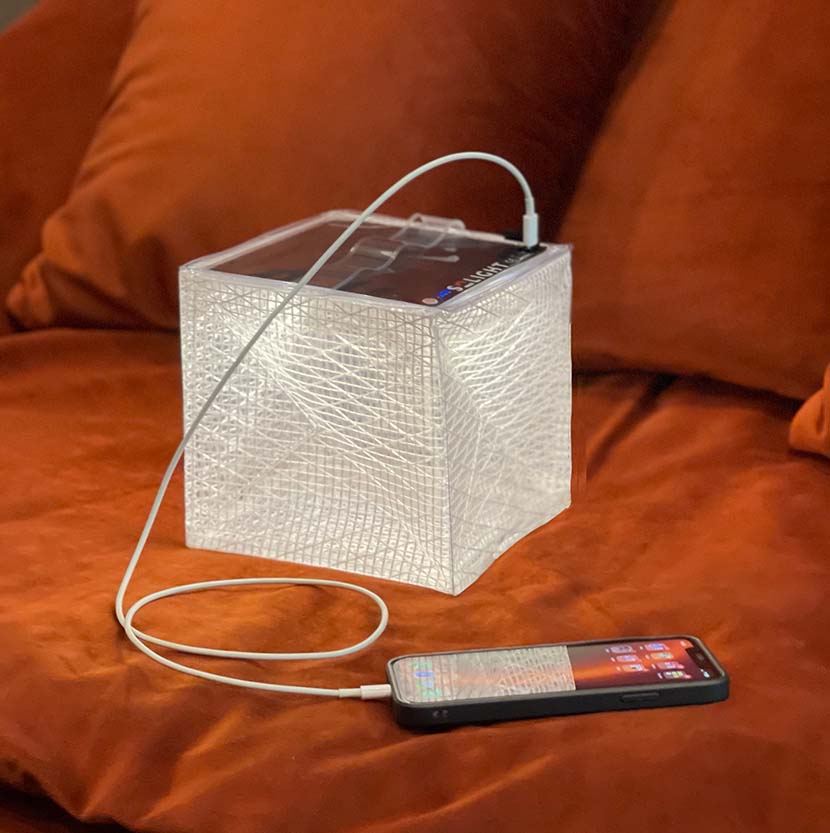 MEGAPUFF lantern charging phone on living room sofa