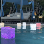 Floating pool lights showing multi-colored solarpuff in magenta light. beauty and function our origami lights are the best for solar lifestyles. 