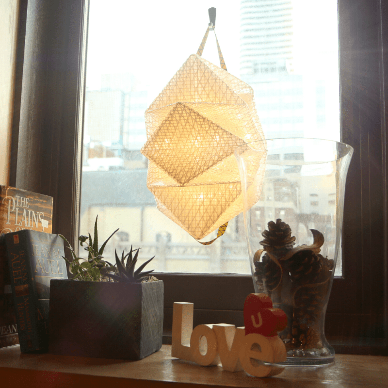 QWNN lantern charging in window hanging from handles, indoor solar light