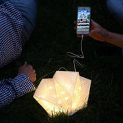 QWNN lantern charging phone outdoors at night, two people on grass