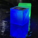 Load image into Gallery viewer, Here the solar cube of light in blue and green. These two cubes are showing the water droplets on the surface as it watches over the pool side. Use it as a bath light and have the colors rotate for a wonderland of color.solar-lantern-waterproof-outdoor-perfect for pool side or picnic- events are so much better with our color solar lights
